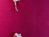 two pieces of silver bracelets on a pink surface