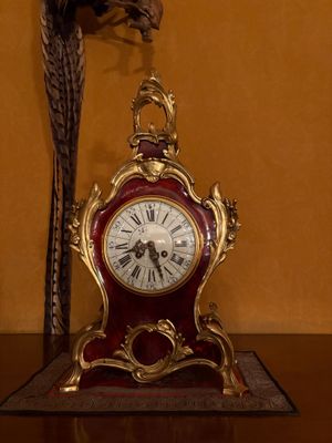 une horloge posée sur une table, avec un oiseau posé dessus