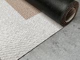 un gros plan sur un rouleau de moquette noire et blanche posé au sol