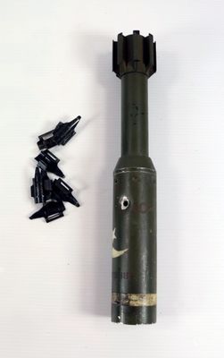 a small metal object with a face on it next to a pair of screws