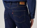 the back of a man in a blue shirt and jeans