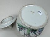 a small vase with a lid on a table