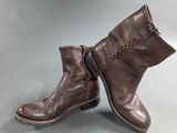 a pair of brown leather boots on a gray surface