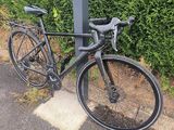 un vélo attaché à un poteau au bord de la route
