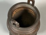 a small metal pot with a handle on a table