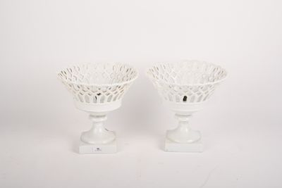 deux vases blancs posés l'un à côté de l'autre sur une table