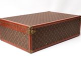 a brown and brown suitcase sitting on a white surface