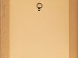 an old book with a ring on top of it