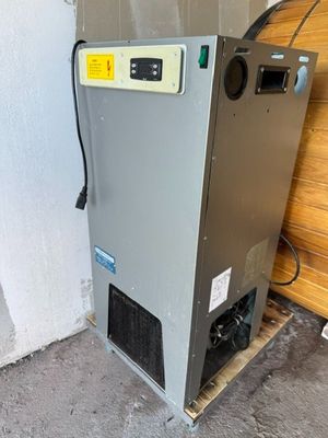 un climatiseur industriel installé dans un garage, contre un mur