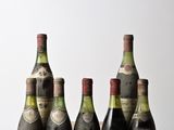 six bouteilles de vin sont alignées sur une table en bois