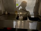 l'ombre d'une personne debout devant un évier de cuisine
