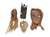 three wooden masks with long hair on a white surface