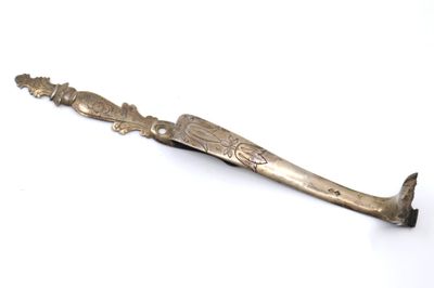 un couteau ancien en argent posé sur une surface blanche, sur fond blanc