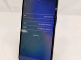 the back of a phone with a broken screen on a white surface