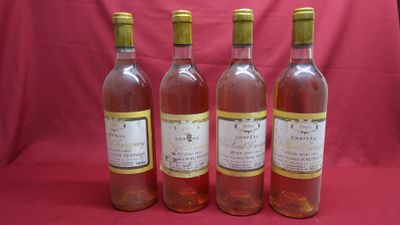 four bottles of wine are lined up on a red background