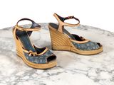 une paire de sandales à talons compensés Louis Vuitton posée sur une table en marbre