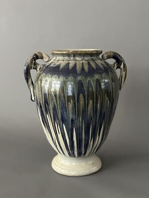 un vase bleu et blanc muni d'anses, sur fond gris