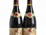 deux bouteilles de vin posées l'une à côté de l'autre sur une surface blanche