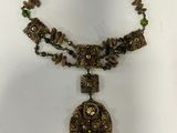an image of a necklace with beads and a pendant on it