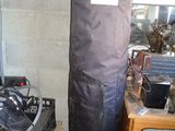 un grand sac noir posé sur une table, à côté d'une pile de cartons