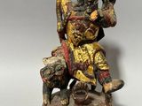 l'image d'une statue d'un homme assis sur un rocher