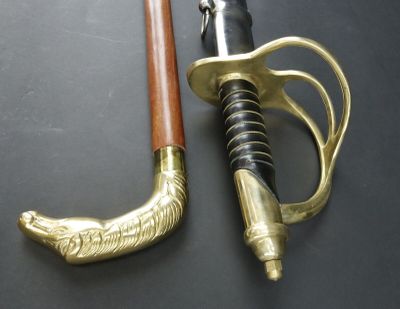 a gold and black sword with a wooden handle on a black surface