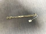 un bracelet en or sur lequel est gravé « here here »