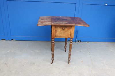 une petite table avec un plateau en bois posée sur un trottoir