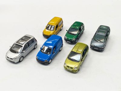 plusieurs petites voitures sont alignées sur une surface blanche