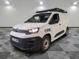 la camionnette blanche est garée dans une pièce au sol en damier
