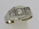 gros plan d'une bague avec des diamants sur une surface blanche