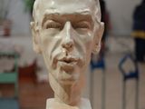 a sculpture of a man ' s face on display in a museum