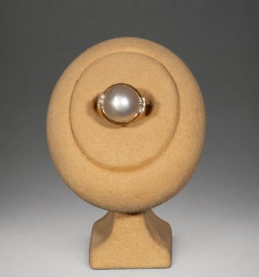 une image représentant une bague en or surmontée d'une perle