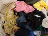 a pile of clothes that is on a bed