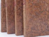 four books lined up in a row on a white surface