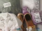 a lot of clothes and shoes that are sitting on a table