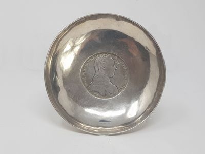 a close up of a silver plate with a coin on it