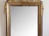 a mirror hanging on the wall with a gold frame