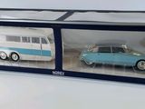 two toy cars in a box on a white surface