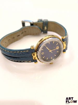une montre posée sur une surface blanche