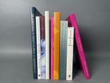 plusieurs livres sont empilés sur une surface grise