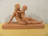 a clay sculpture of a woman and a man sitting on a table