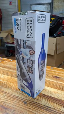 emballage d'un aspirateur Black & Decker posé sur une table en bois