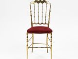 a gold and red chair with a red cushion