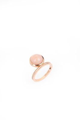 un gros plan d'une bague en pierre rose sur fond blanc