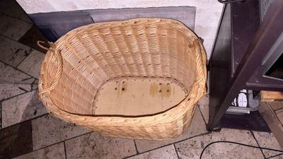 a wicker basket sitting on the floor next to a stove