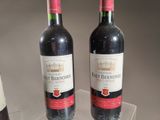 two bottles of wine sitting on a clear table