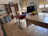 une pièce équipée d'un bureau, d'étagères et d'un réfrigérateur