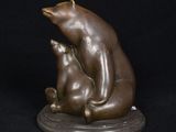bronze sculpture of a bear and a cat sitting on a base