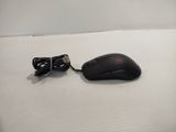 a black mouse and a black cord on a white surface